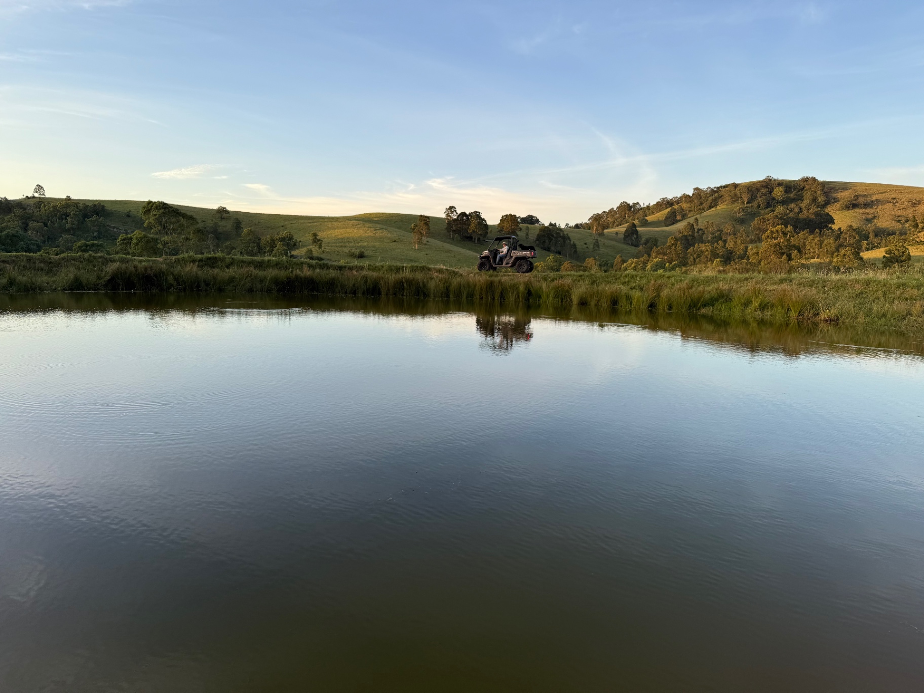 Rural property with a dam, rolling green hills and grazing pasture